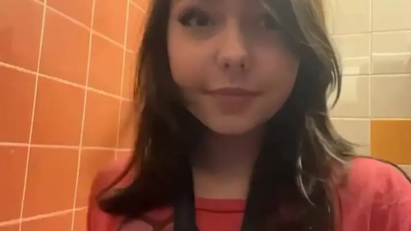 Beautiful college girl flashing in the bathroom
