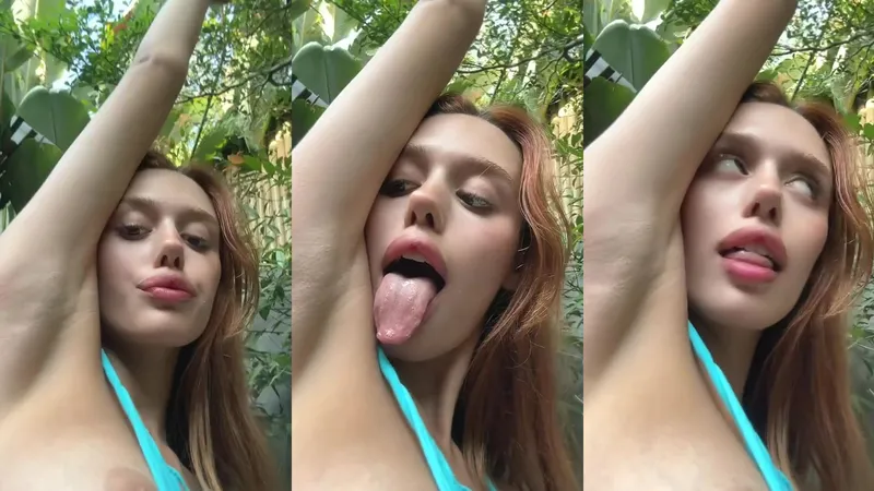 18 Sexy redhead teases tongue out, perky tits in blue.